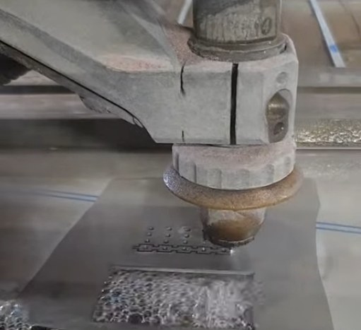 Waterjet cutting head cutting a steel plate